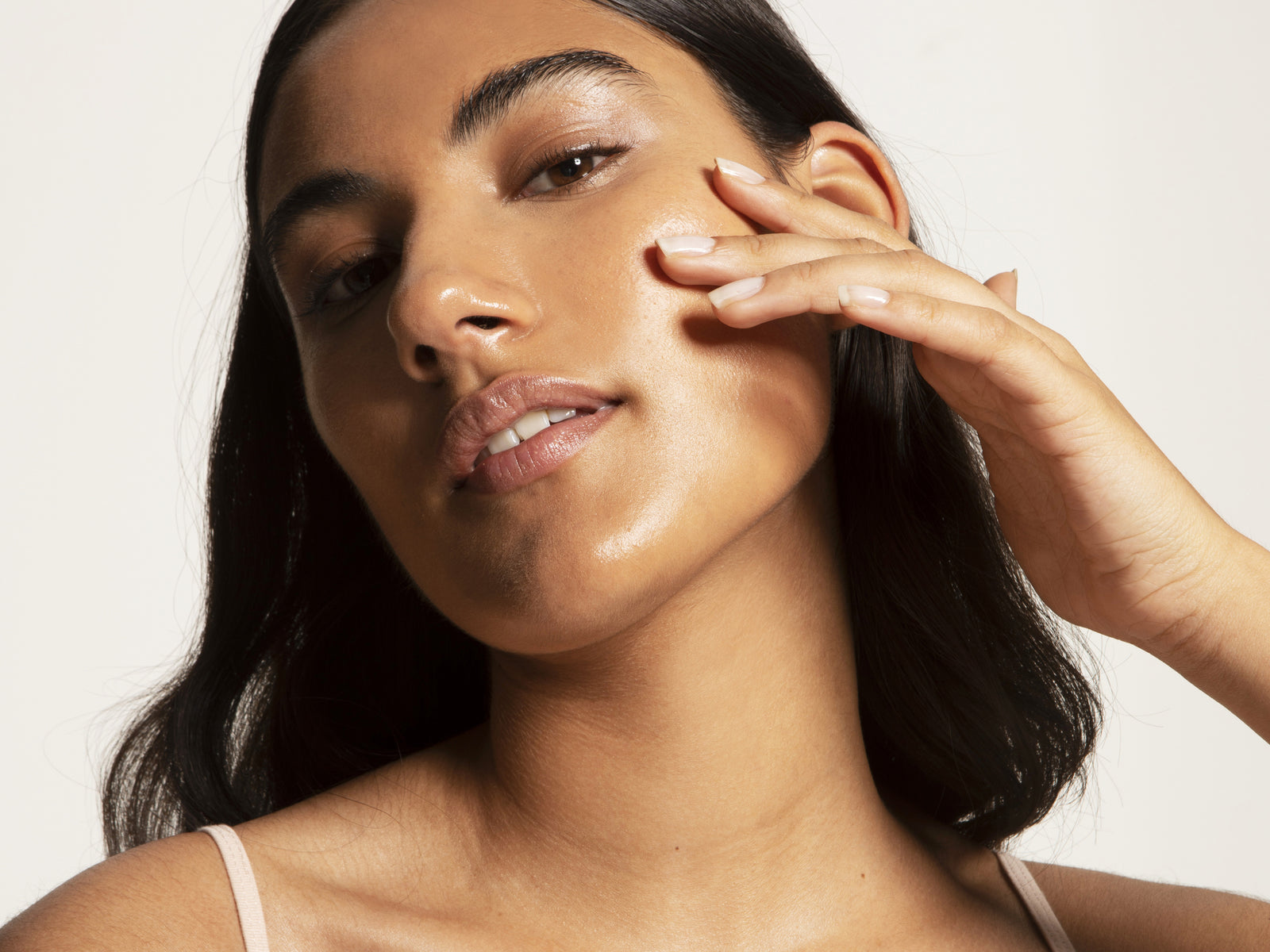 woman applying a face serum on her skin for glowing, healthy radiance