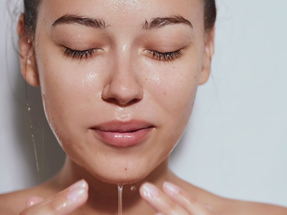 woman rinsing her face with water